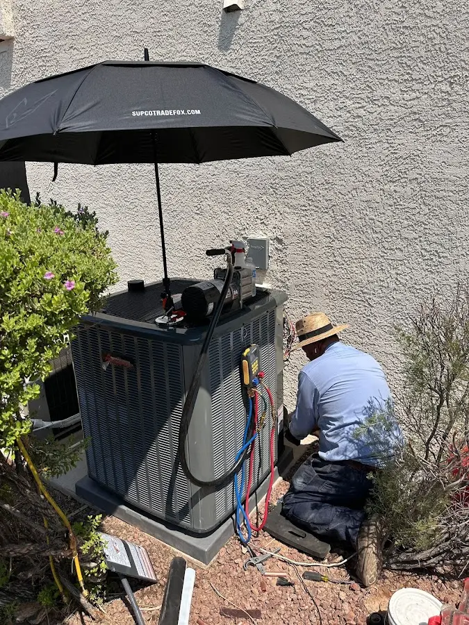 HVAC technician performing outdoor AC maintenance in D'Iberville